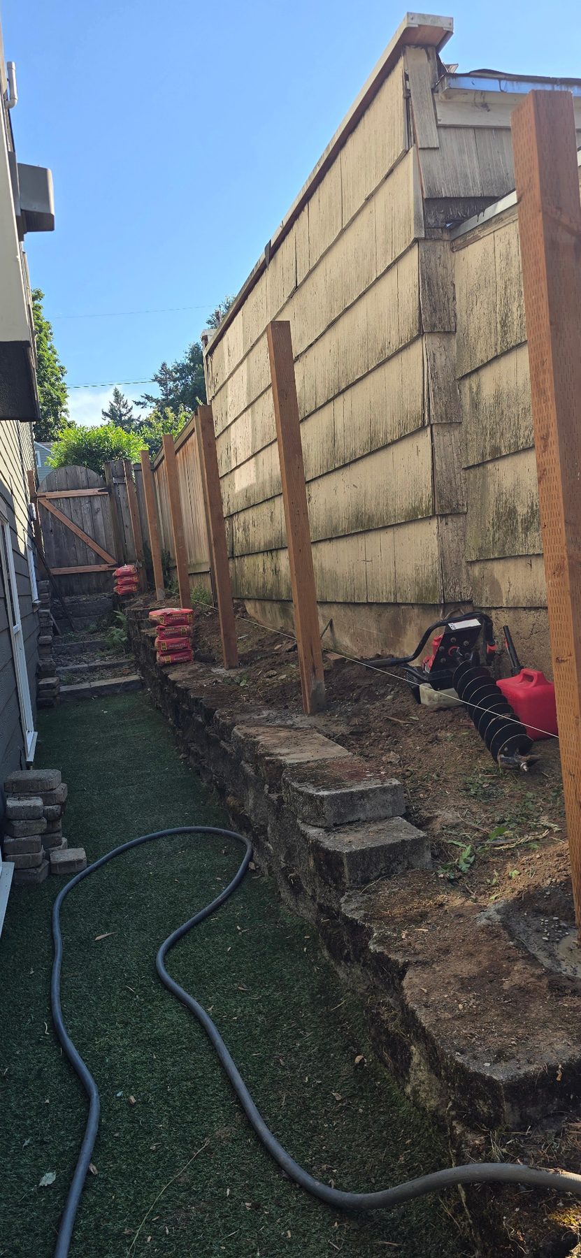 Old fence removed and new fence posts being set in a narrow side yard