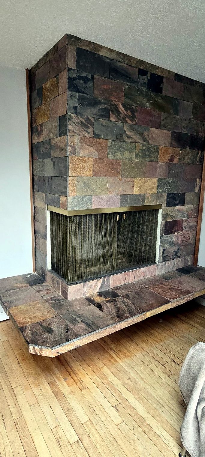 Original slate-tiled fireplace in a Portland living room before renovation