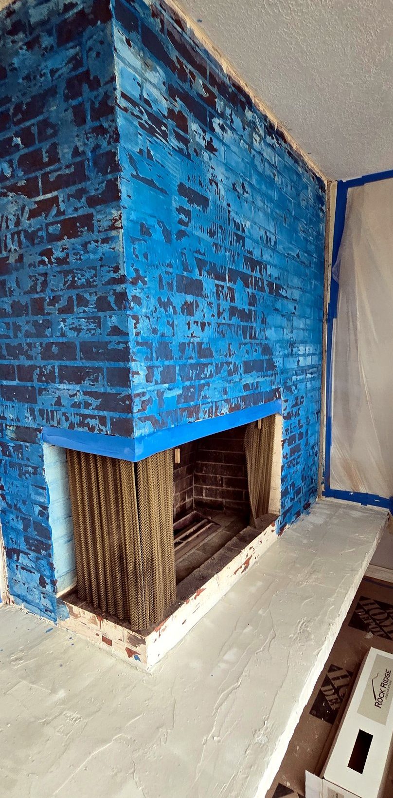 Fireplace brick coated in a blue bonding primer ahead of new stone