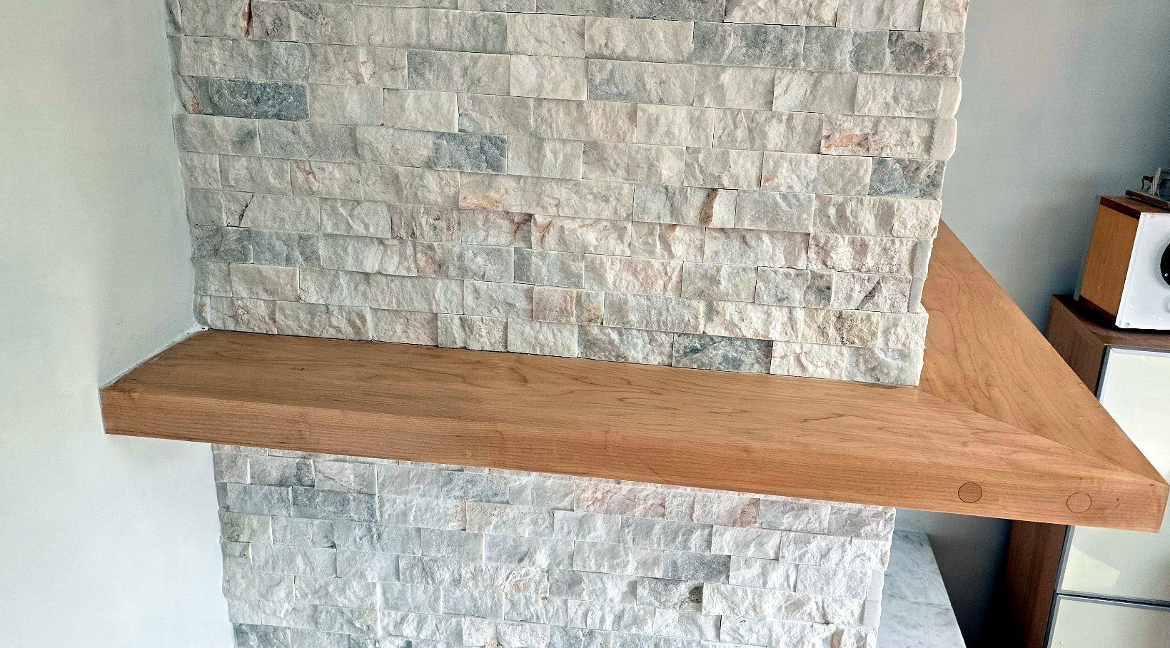 Hardwood shelf corner with plugged fasteners on the finished fireplace
