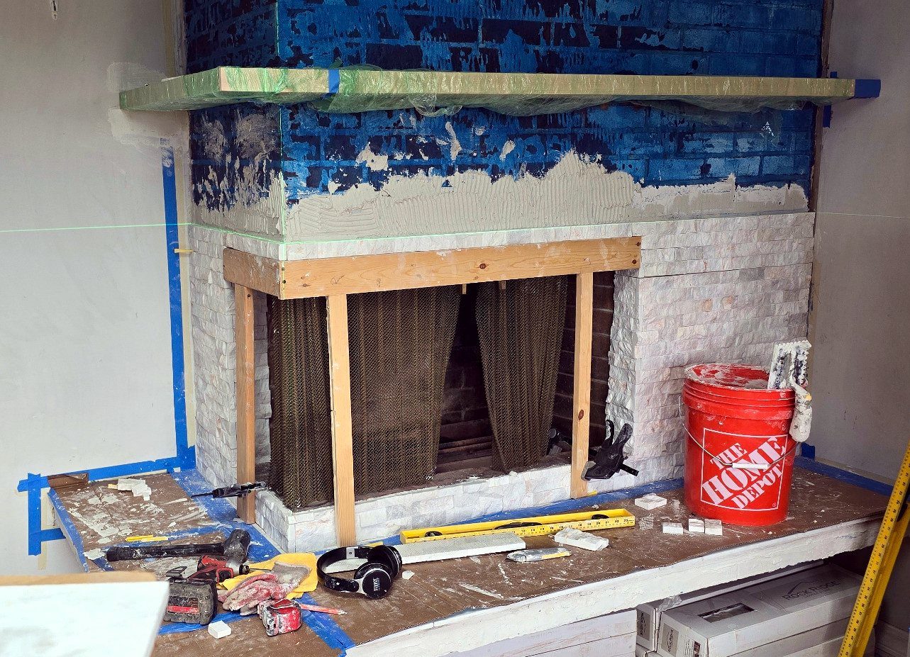 Manufactured stone ledger starting on the lower fireplace face on a laser level line