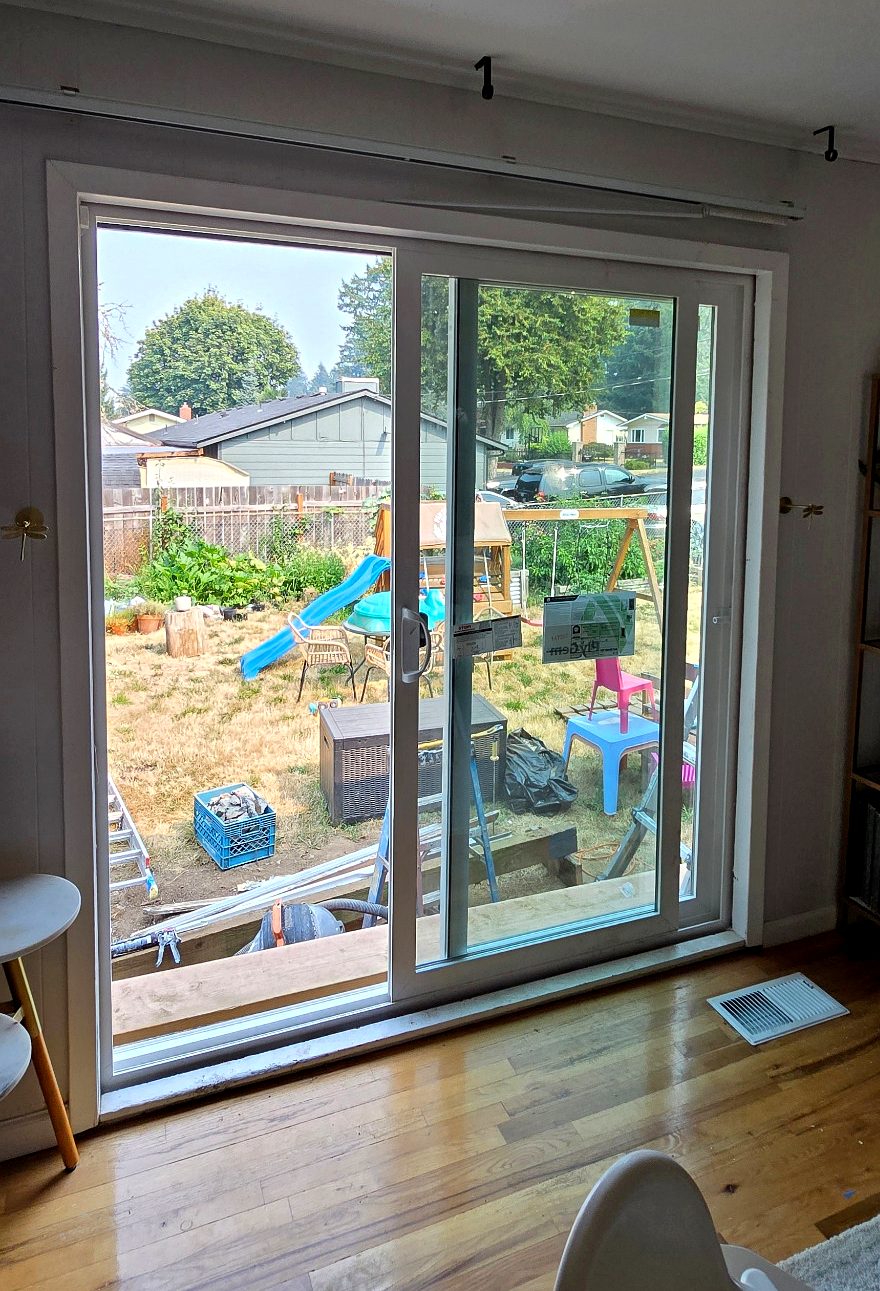 Completed sliding patio door with new interior trim above a hardwood floor