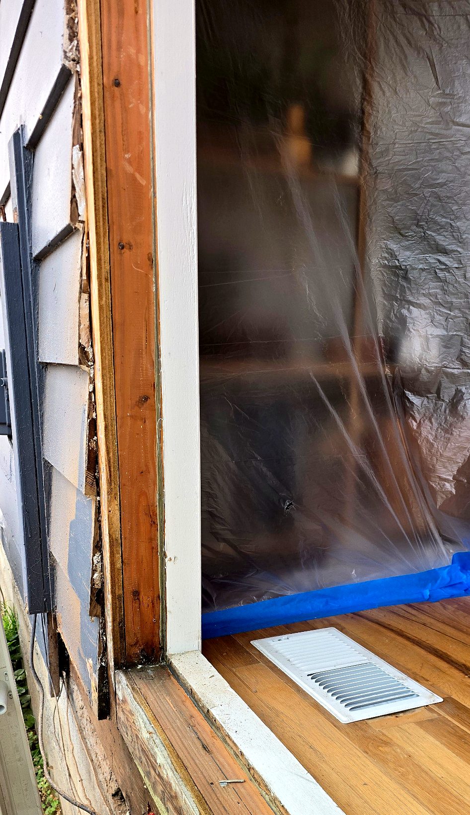 Plastic sheeting taped across the door opening to protect the room during the work