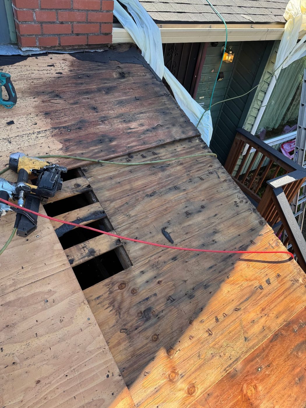 Damaged roof decking opened up for repair near the chimney