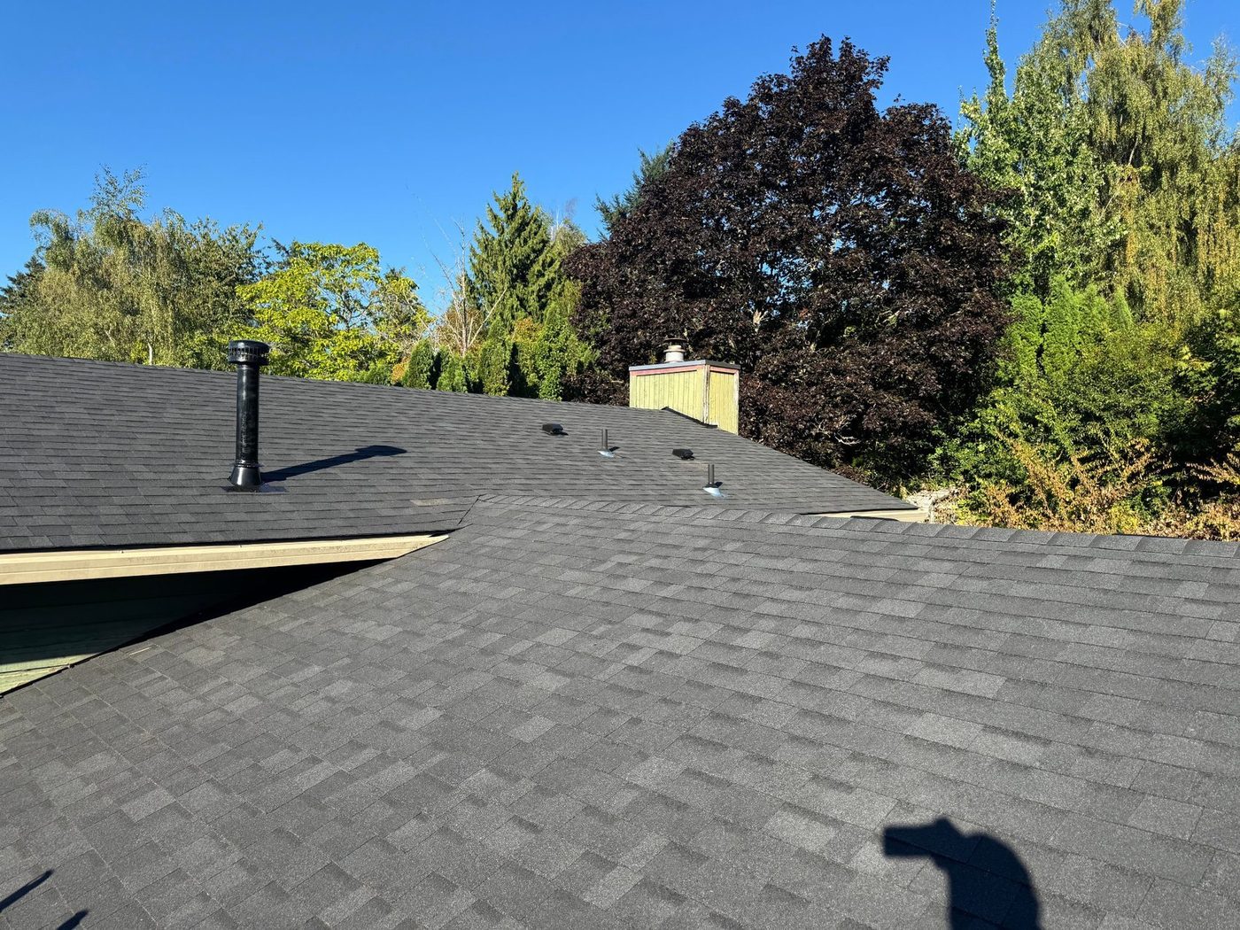 Finished roof with vents and chimney integrated into the new roofing