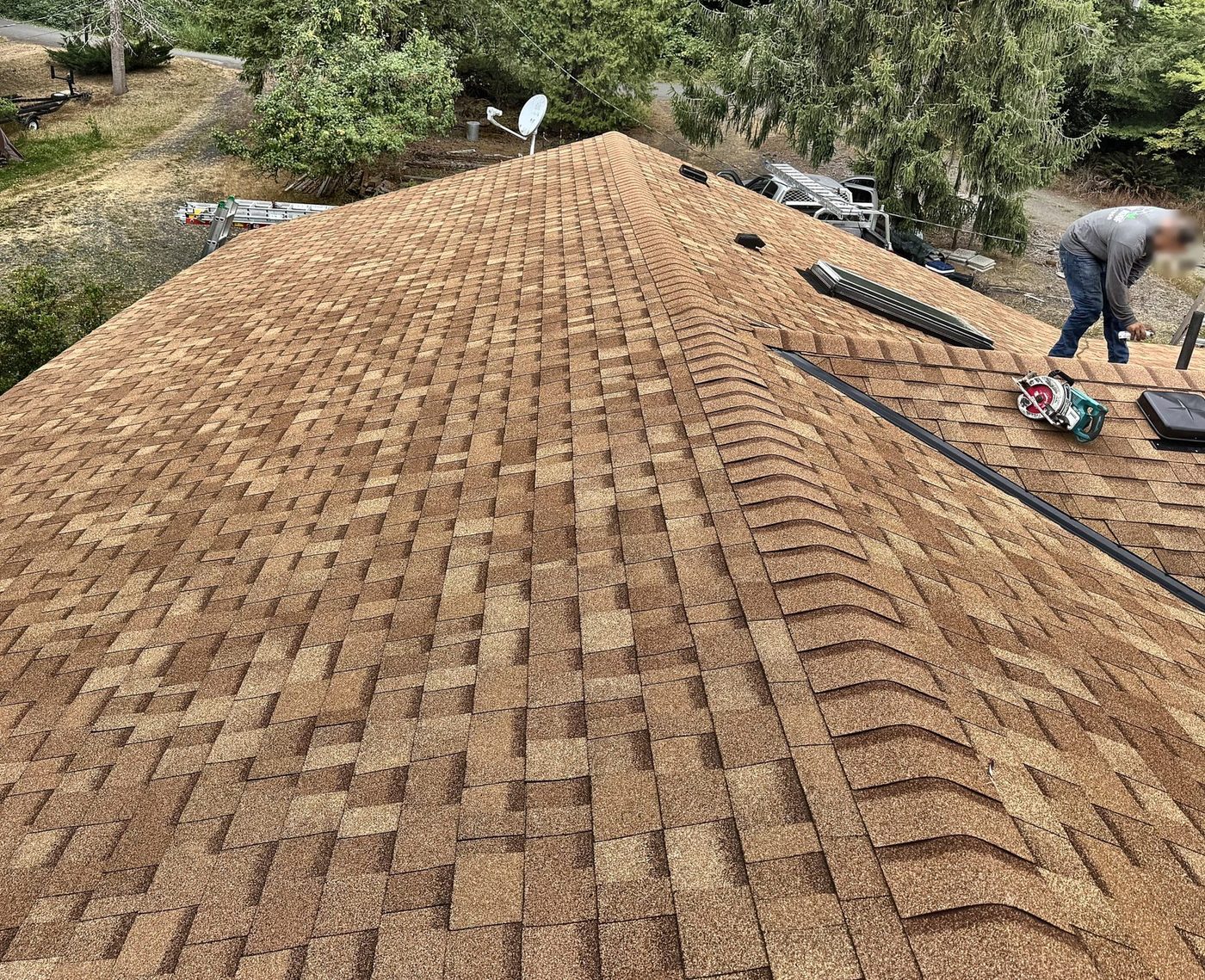 Owens Corning Oakridge Desert Tan architectural shingles with hip and ridge caps being installed on a Columbia County roof
