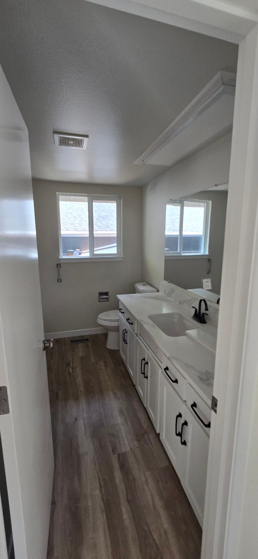 Renovated bathroom with new white vanity, fixtures and flooring