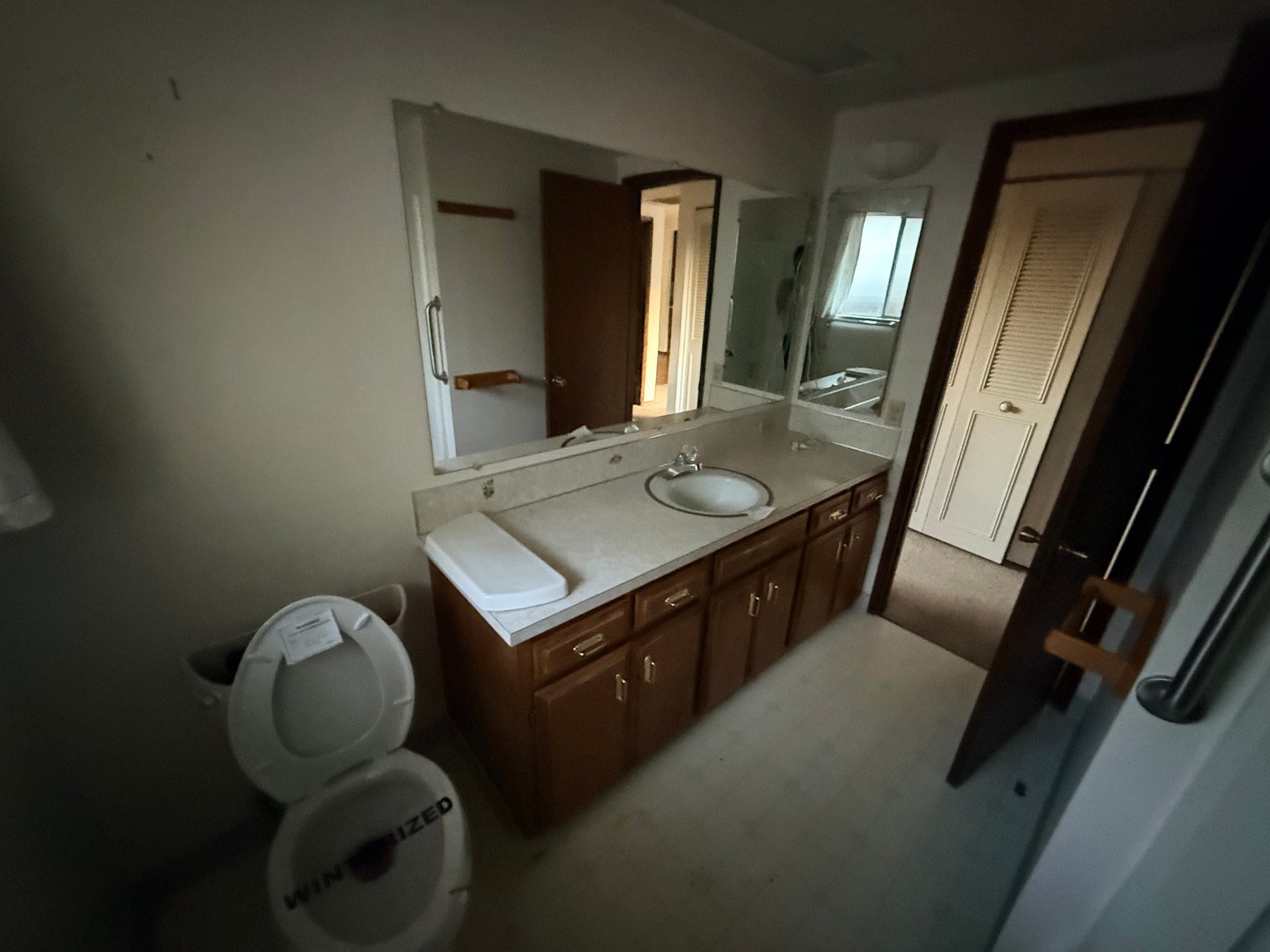 Dated bathroom before renovation with old vanity and worn finishes