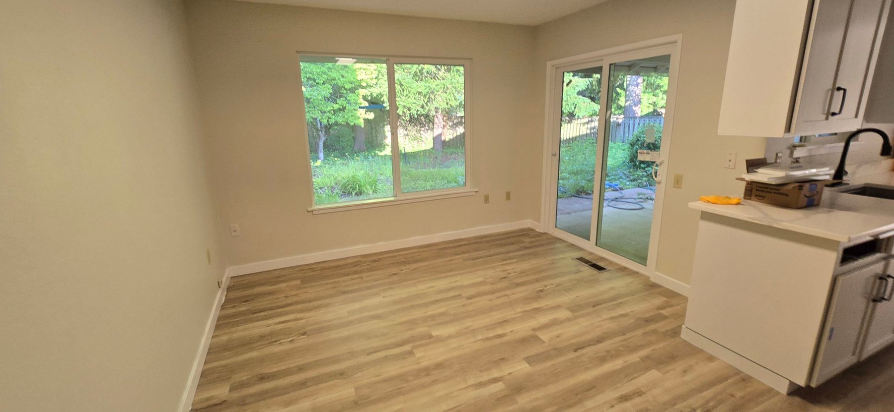 Renovated living area with new wood-look flooring and fresh paint