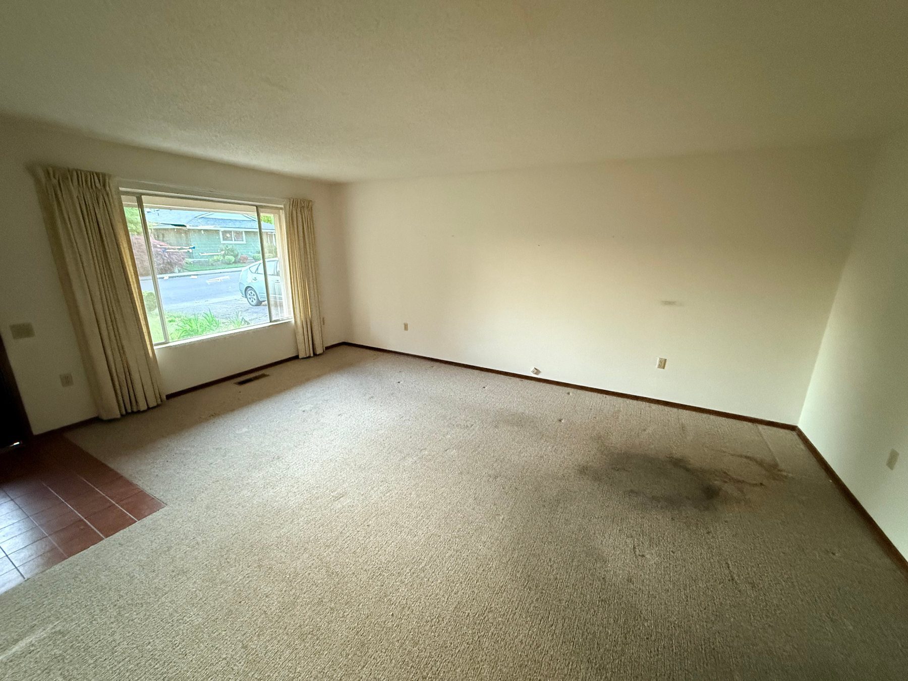 Living area before renovation with worn carpet